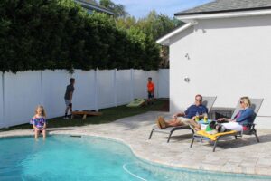 Family enjoying time by the pool in their backyard. 